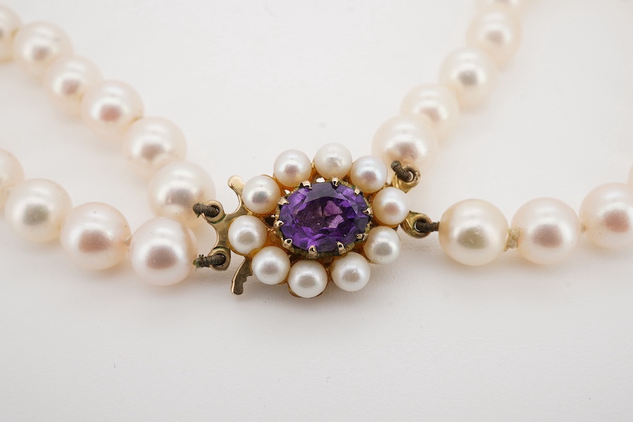 A modern twin strand cultured pearl necklace, with amethyst and cultured pearl cluster set 9ct gold clasp, 44cm. Condition - fair to good